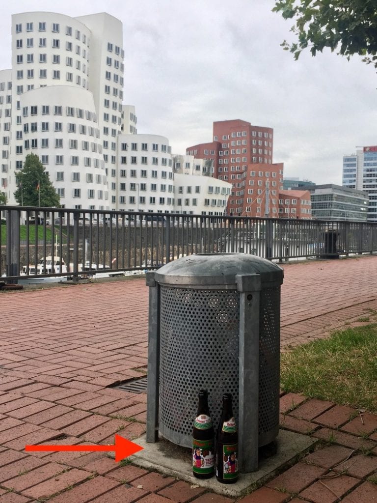 Two bottles next to a trash can in Germany