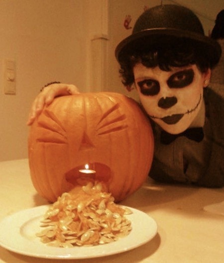 Sugar Skull costume for Halloween with a carved pumpkin